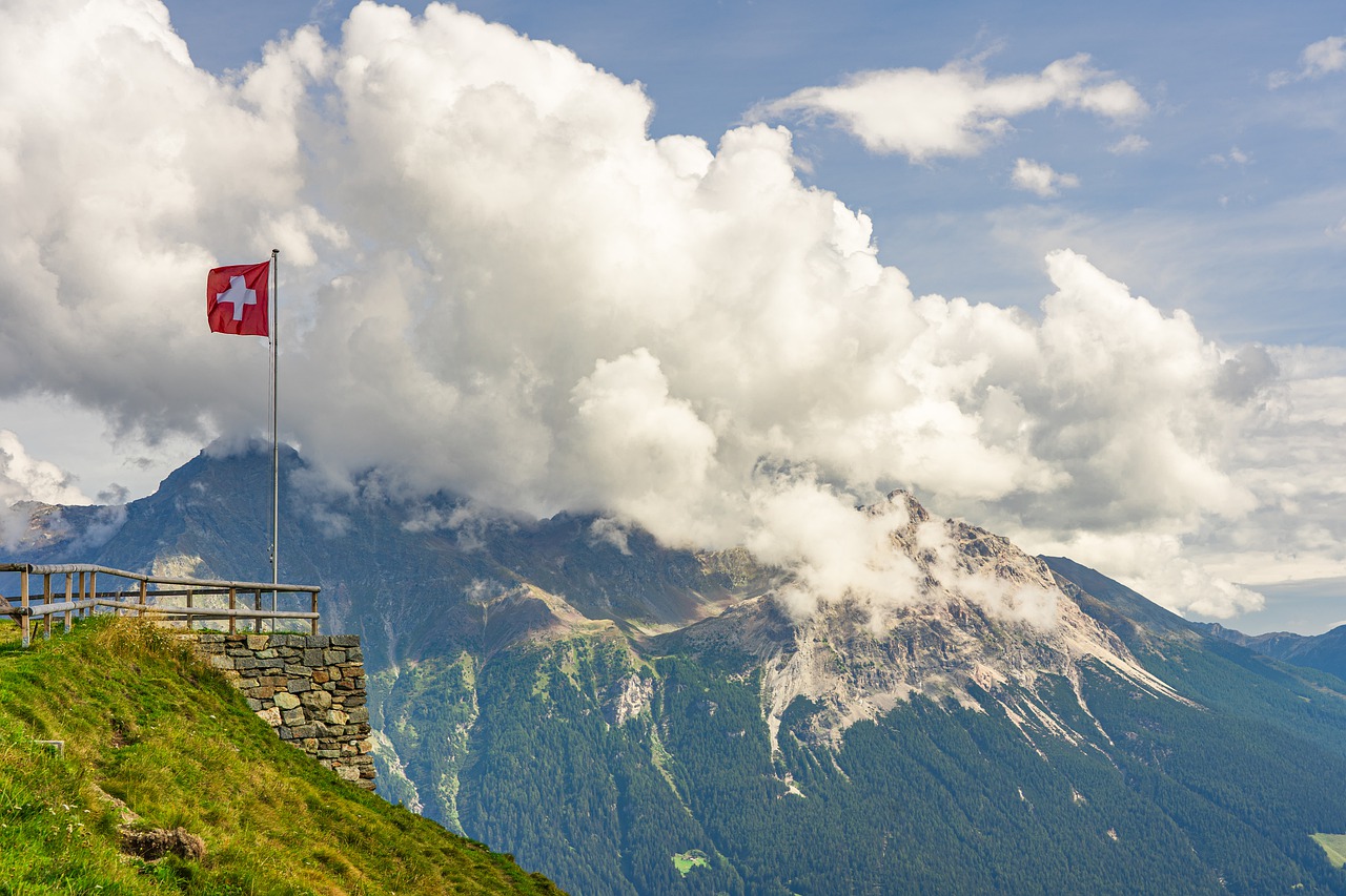 Un drapeau Suisse avec des montagnes en second plan