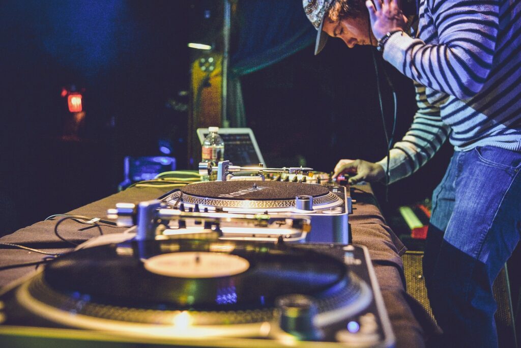 Photographie d'un DJ devant ses platines vinyle.